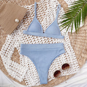 Light blue ribbed triangle bikini with high-waist brief and white cover-up.