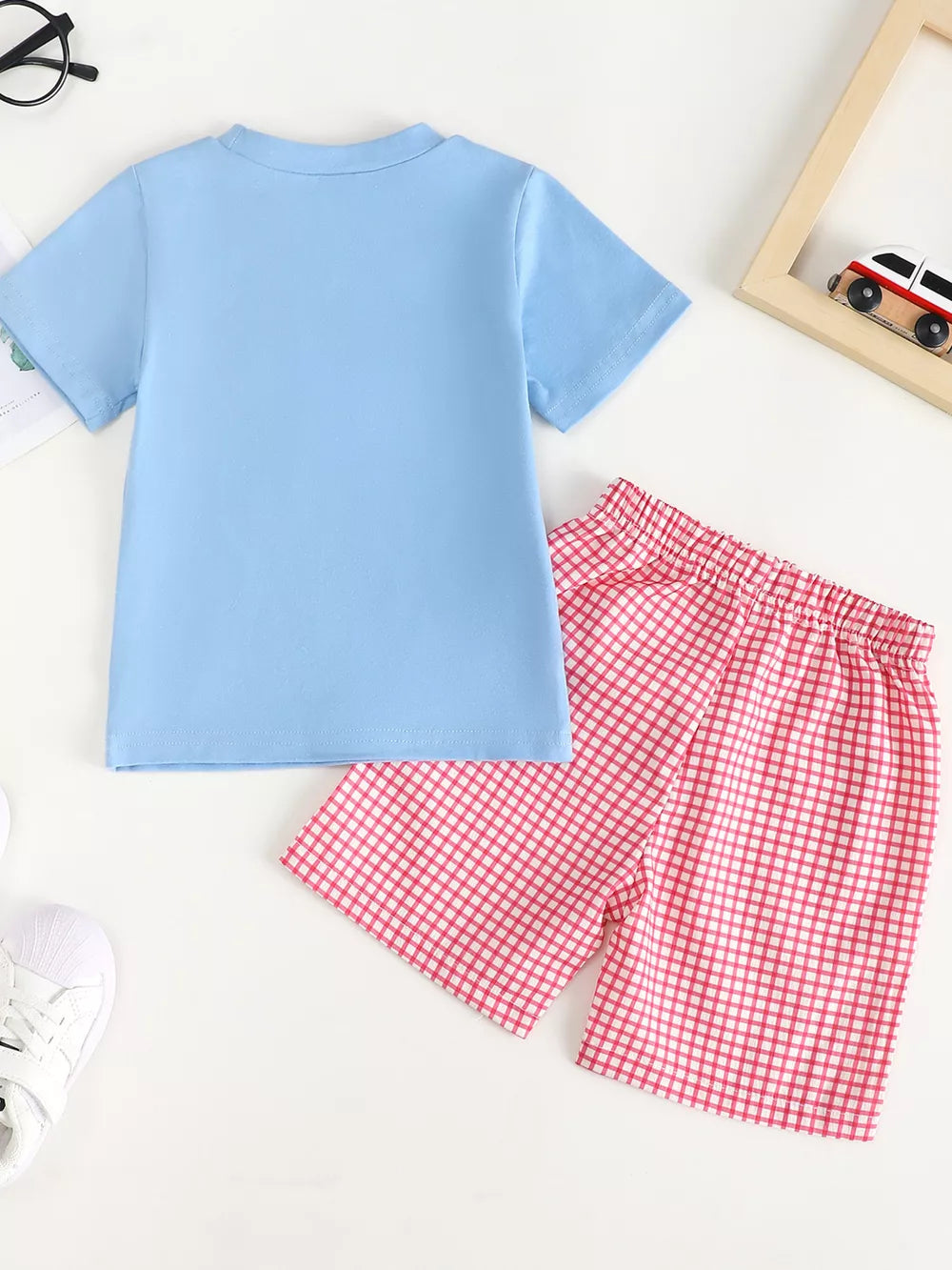 Baby blue t-shirt and pink gingham shorts set with playful chicken appliqué detail.