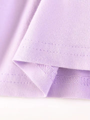 Lavender cotton baby dress hem detail with ruffled edge and stitching.