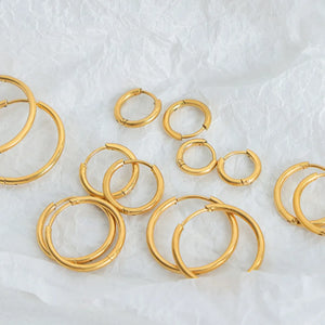 Gold vermeil huggie earrings in various sizes, displayed on white paper.