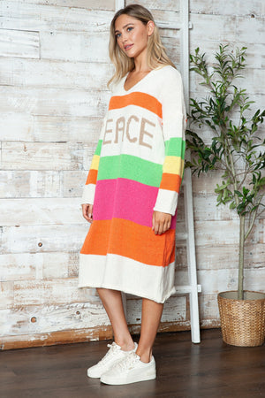 Beige midi sweater dress with rainbow stripes and "PEACE" lettering