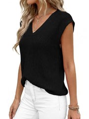 Black textured V-neck sweater vest with cap sleeves, styled with necklaces.