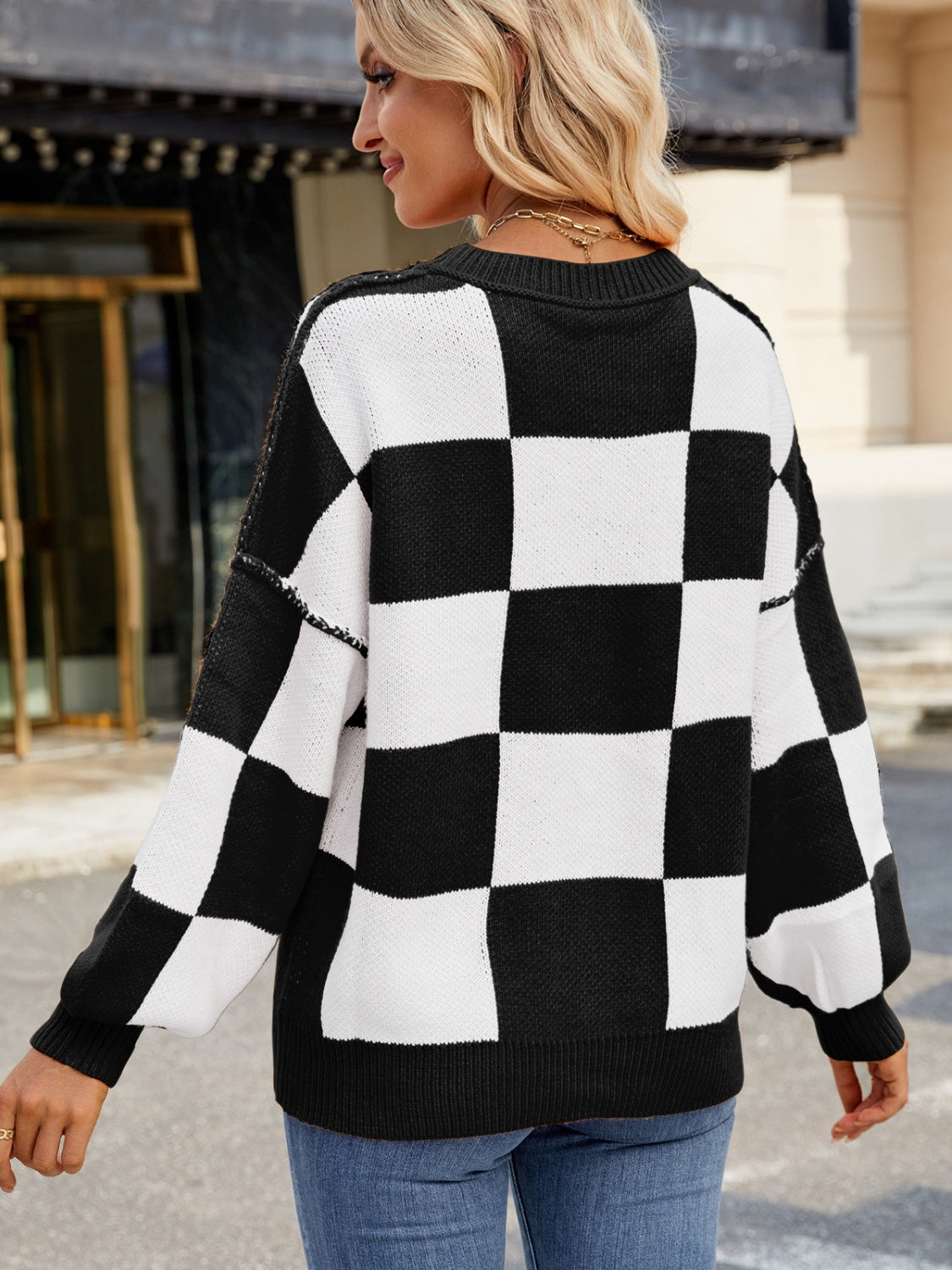 Checkerboard knit sweater in black and white with balloon sleeves and crew neck.