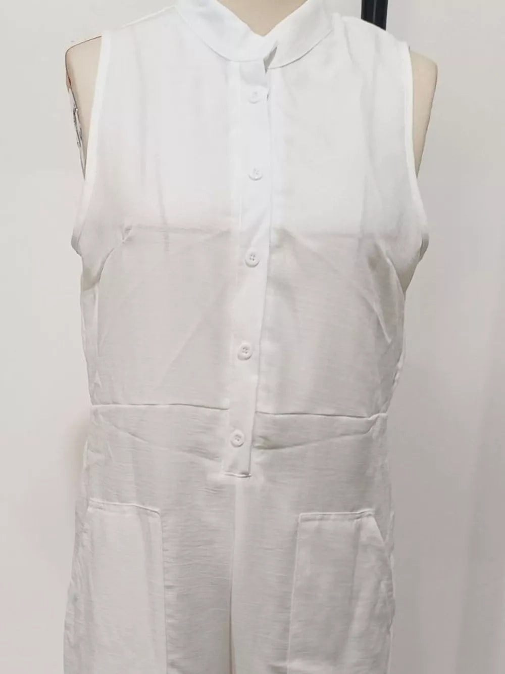 White sleeveless button-down romper with collar and pockets
