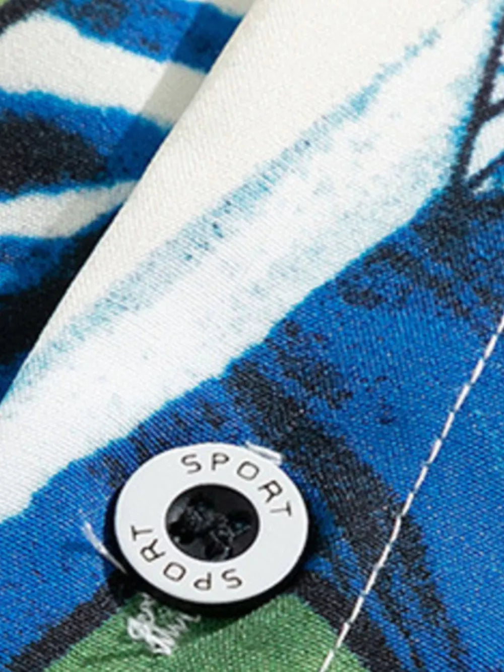 Tropical print oversized button-up shirt in blue, white, and green cotton with a white button detail.