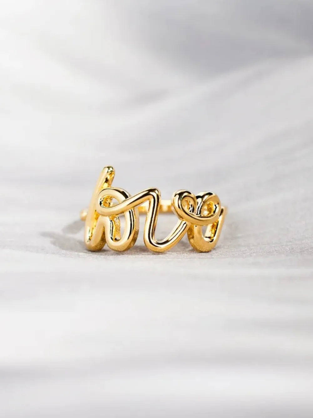 Gold script "Love" ring with a casual, modern design.
