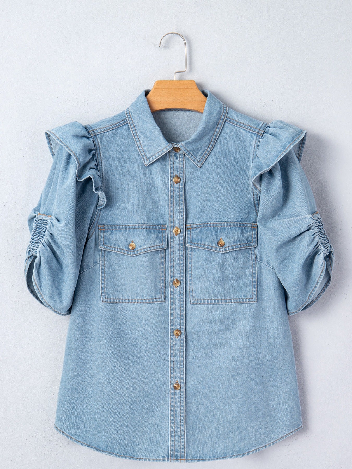 Light wash denim button-down shirt with ruffled short sleeves and ruched cuffs.
