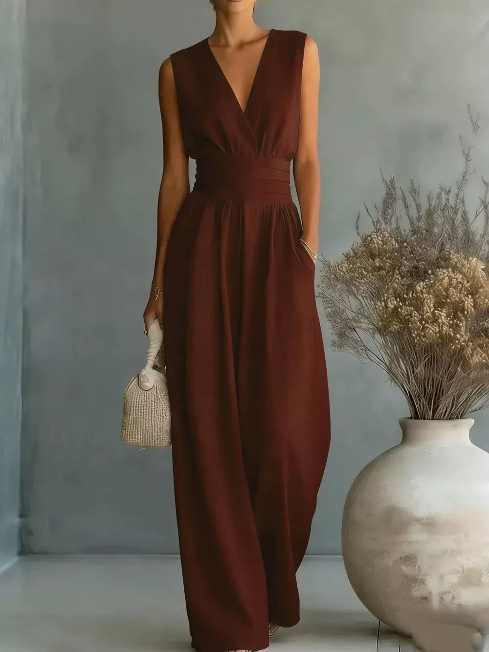 Burgundy sleeveless wide-leg jumpsuit with V-neck, cinched waist, and pockets.