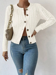 White cable-knit button-front cardigan with round neckline and brown buttons.