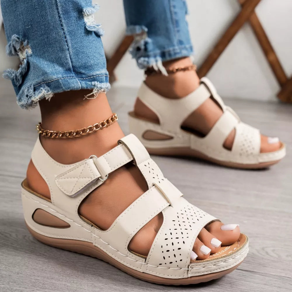 Elegant perforated mid-wedge sandals in gray/white with adjustable straps and a comfortable sole.