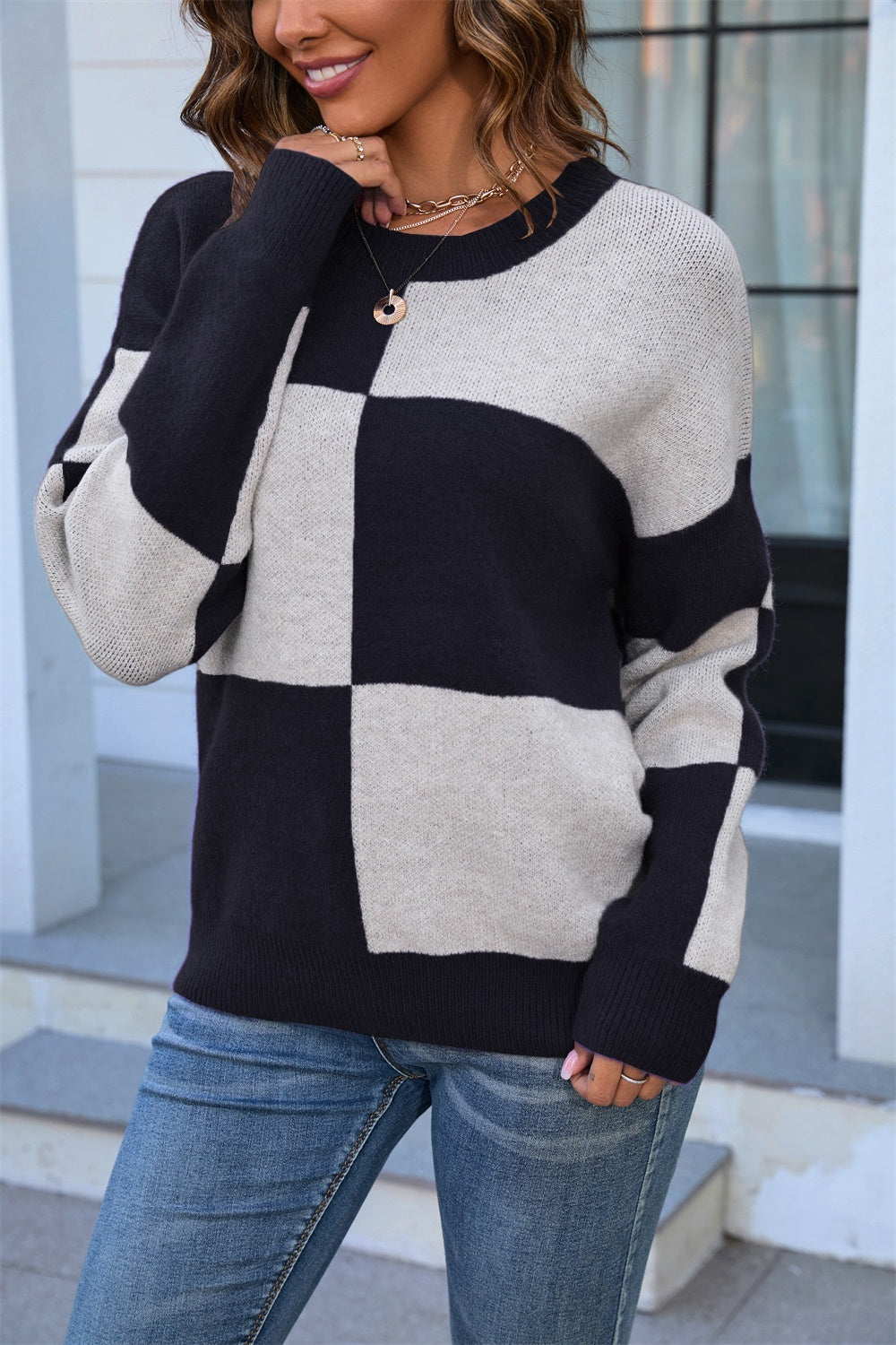 Checkerboard knit crewneck sweater in black and beige acrylic with crew neckline.
