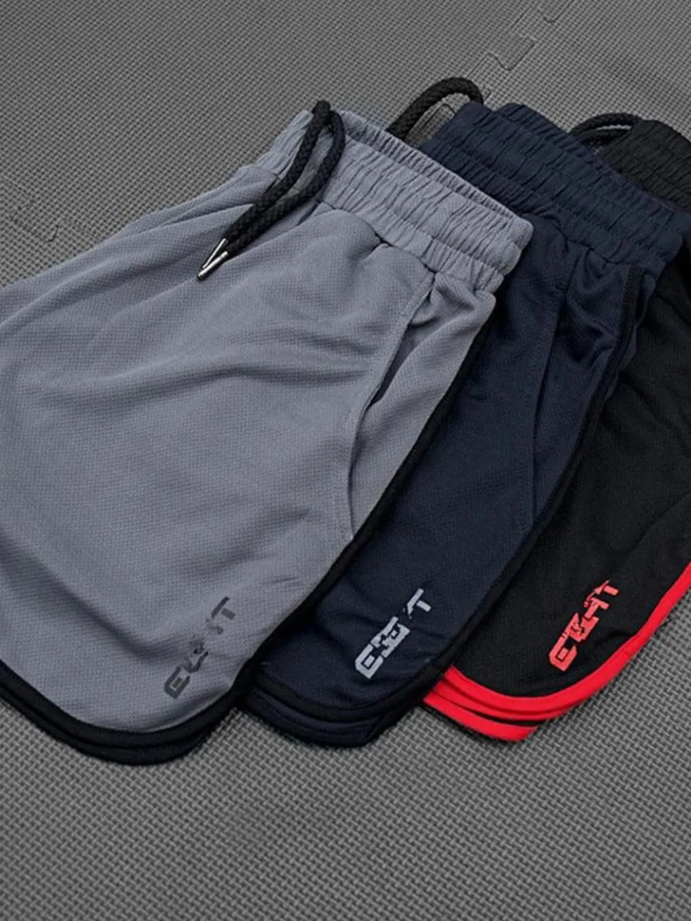 Performance shorts with contrast piping in black, royal blue, and dark gray.