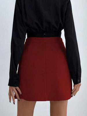 Burgundy asymmetric mini skirt with button detail at the waist