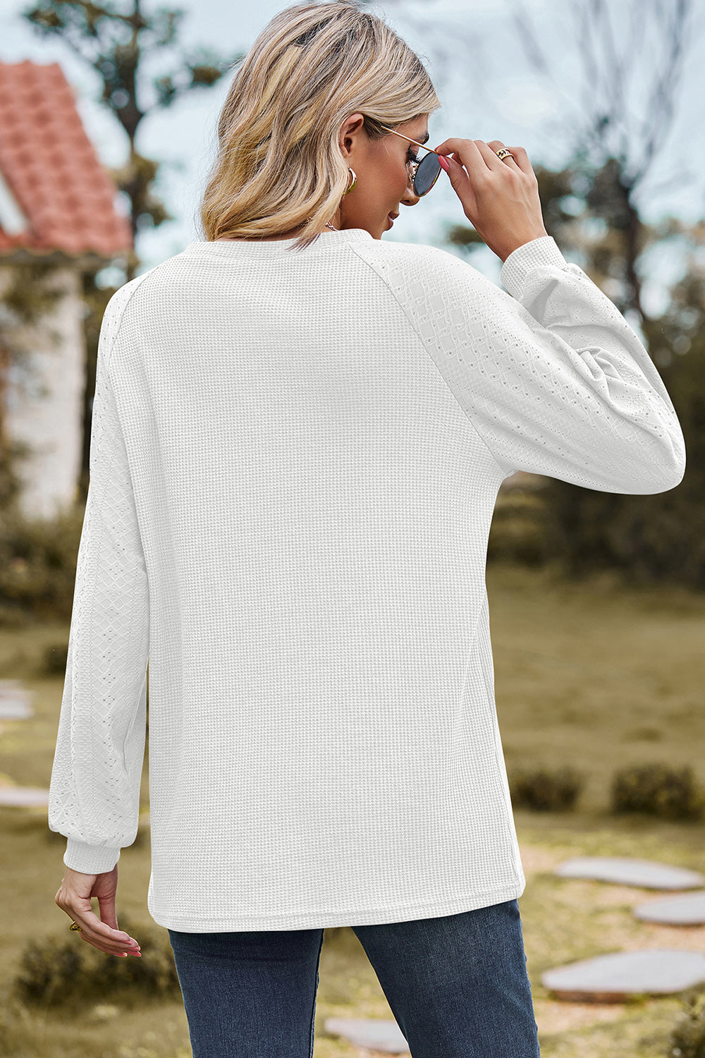 White waffle knit raglan sleeve top with eyelet detail on sleeves.