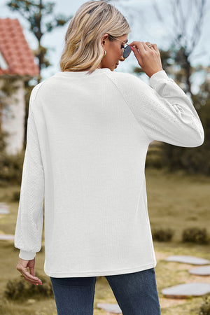 White waffle knit raglan sleeve top with eyelet detail on sleeves.