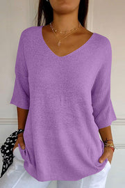 Lavender v-neck knit sweater with flared sleeves and a textured knit.