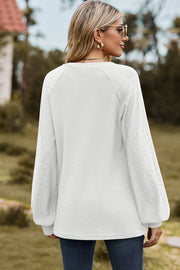 White waffle knit raglan top with eyelet detail on sleeves.