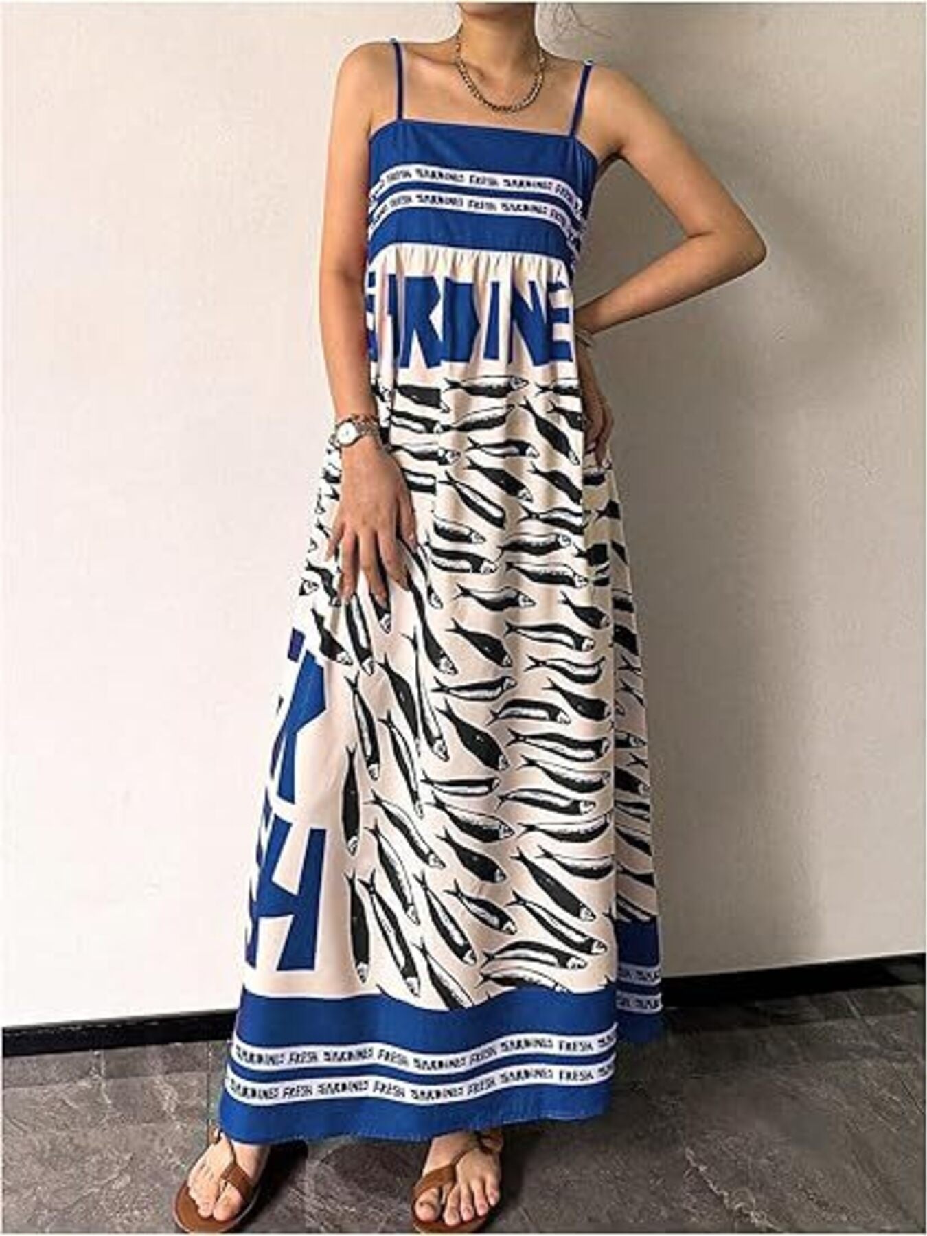 Blue spaghetti strap maxi dress with all-over sardine print and bold text detail.
