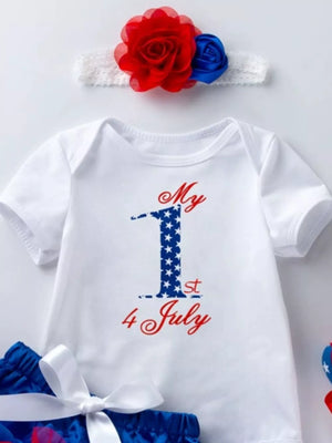 White baby onesie with "My 1st 4 July" patriotic print and floral headband.