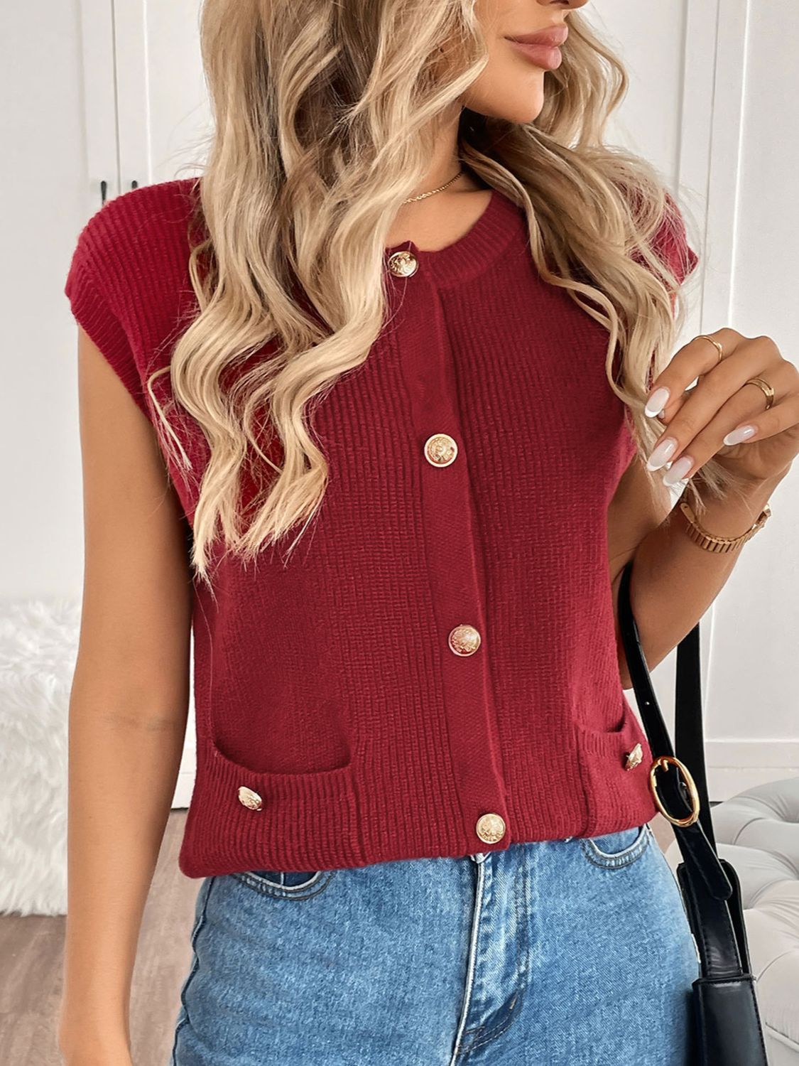 Ribbed knit vest in rust with gold buttons and pocket details.