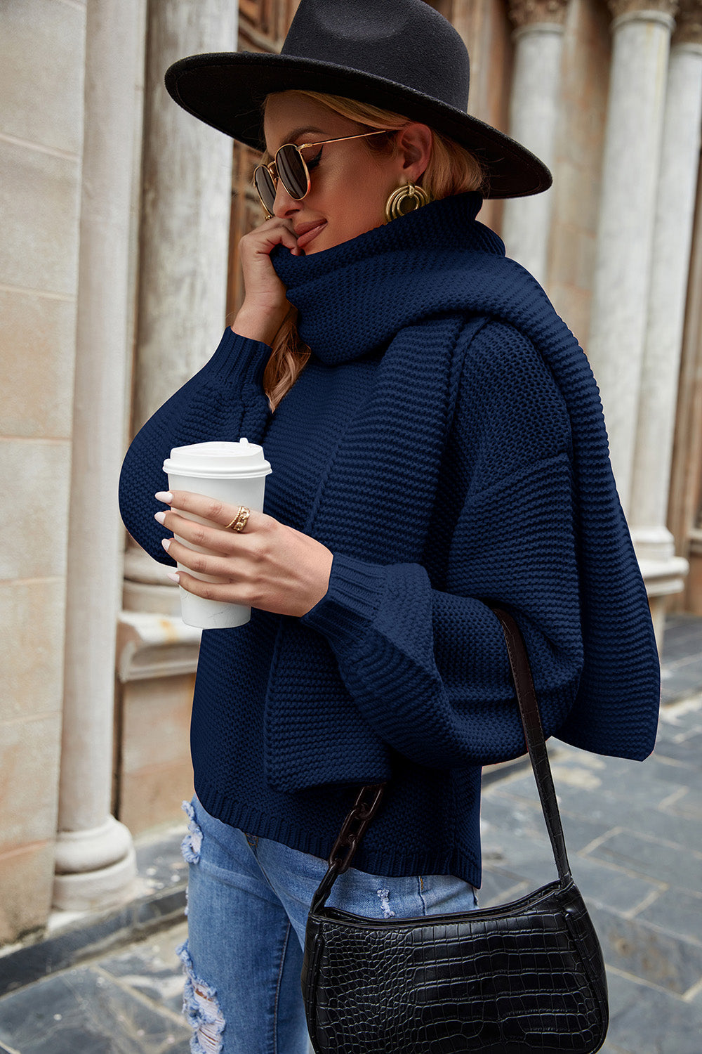 Navy ribbed knit sweater with balloon sleeves and a cowl neck, styled with a scarf.