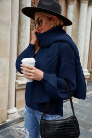 Navy ribbed knit sweater with balloon sleeves and a cowl neck, styled with a scarf.
