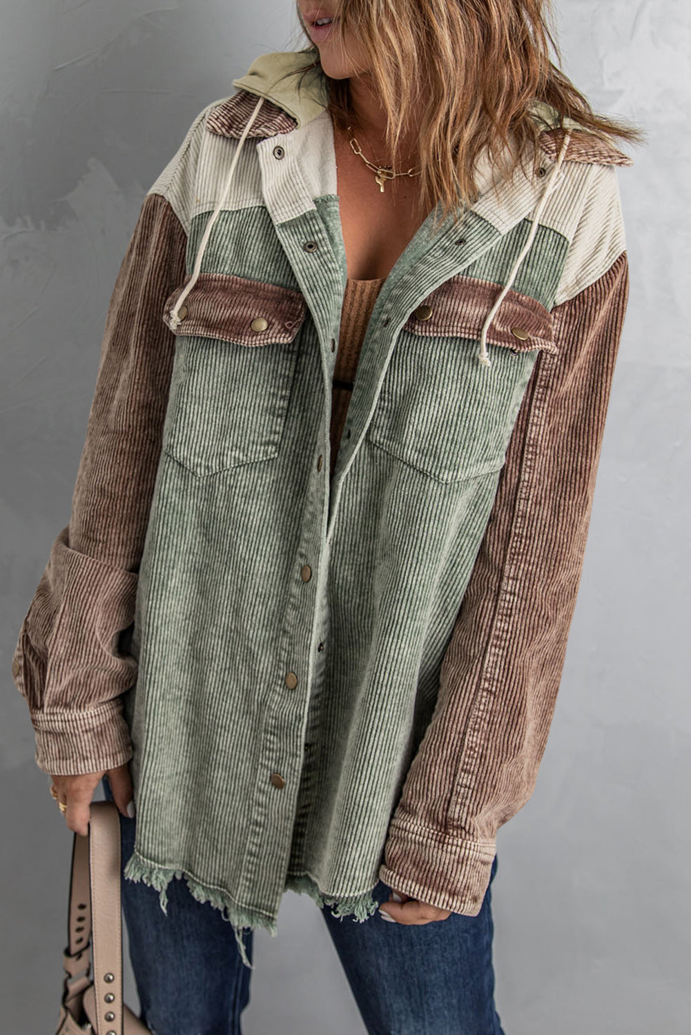Colorblock corduroy hooded utility jacket in green, tan, and cream with frayed hem.