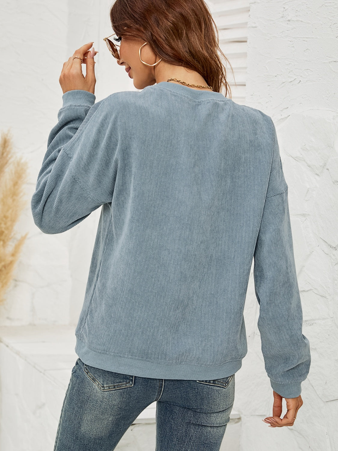 Light blue corduroy sweatshirt with crew neck and long sleeves.