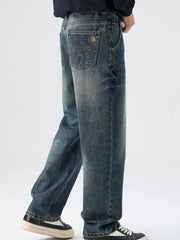 Men's relaxed fit vintage wash denim jeans with distressed details and graphic back pocket.