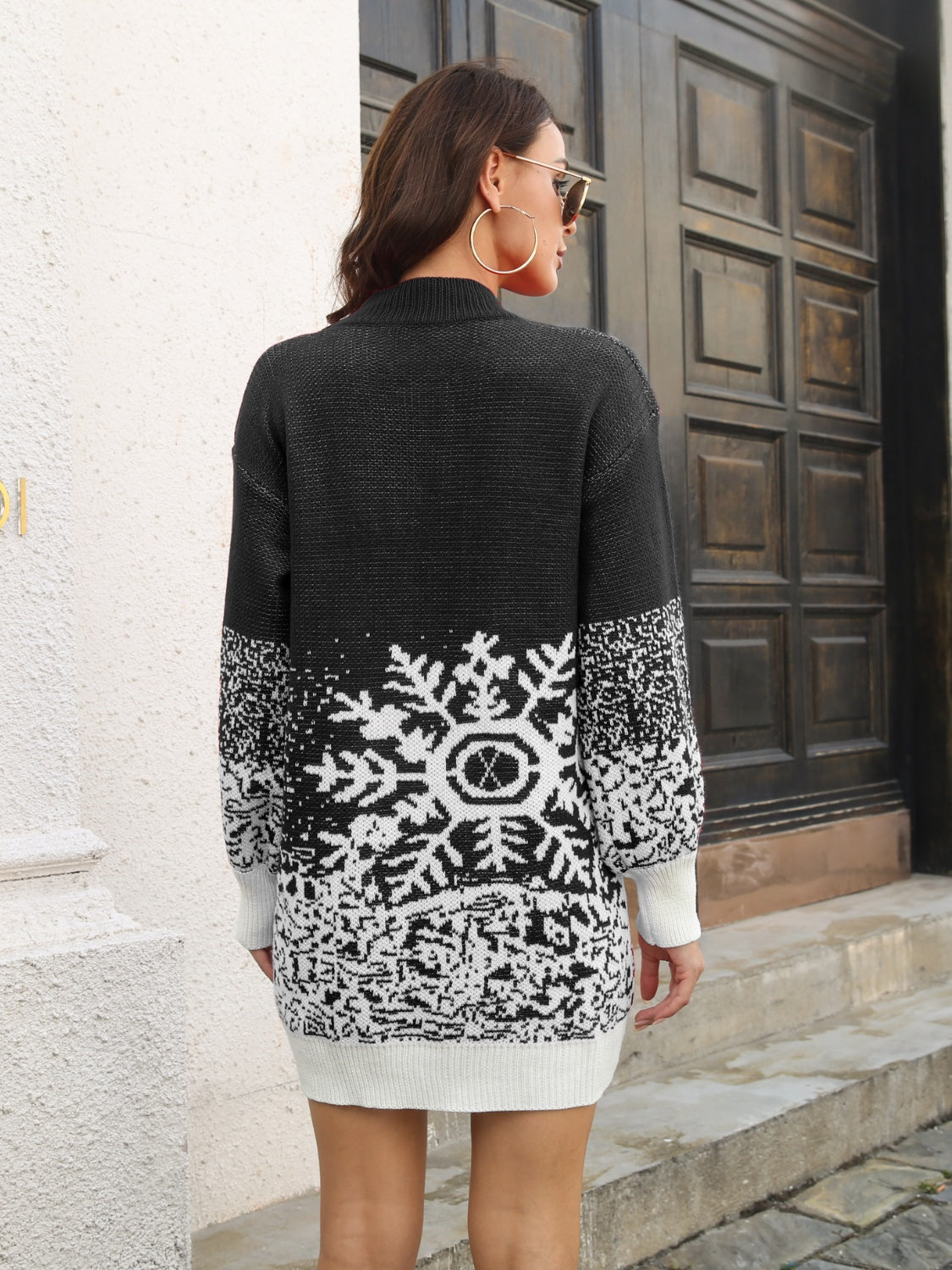 Black knit mini dress with snowflake intarsia pattern, crew neck, long sleeves, and ribbed trim.