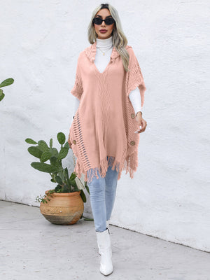 Textured knit poncho in watermelon pink with fringe, wooden buttons, and V-neck.