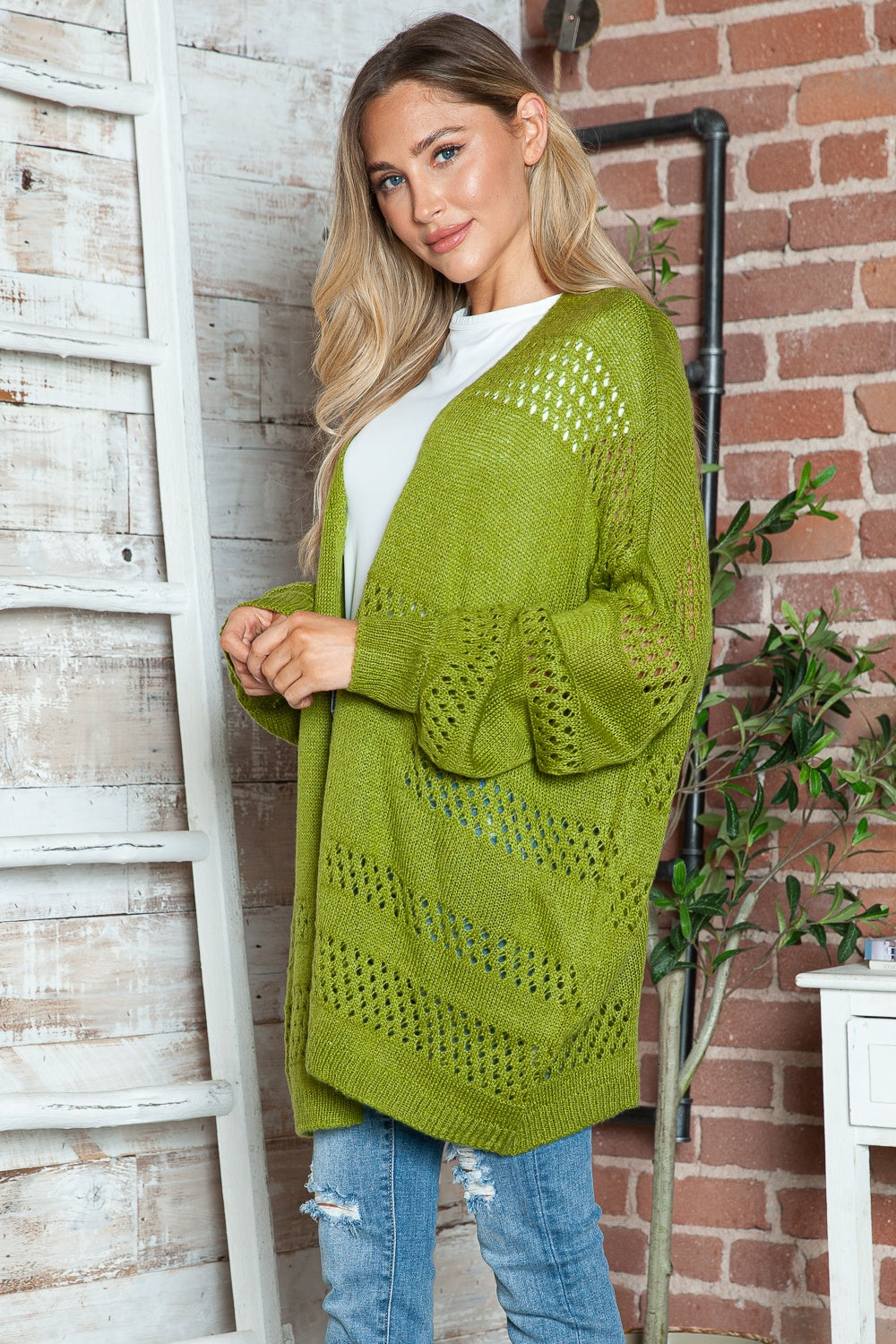 Open-knit slouchy cardigan in matcha green with balloon sleeves and open weave detail.