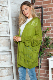 Open-knit slouchy cardigan in matcha green with balloon sleeves and open weave detail.