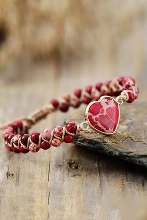 Red heart stone braided bracelet with natural stone beads and gold-tone setting.