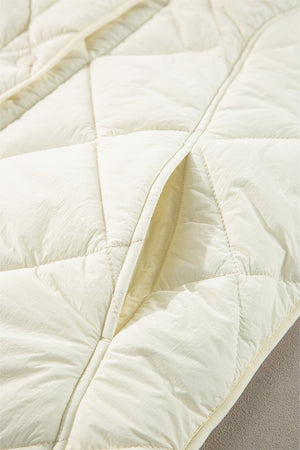 Ivory quilted vest with diamond pattern and a visible pocket detail.