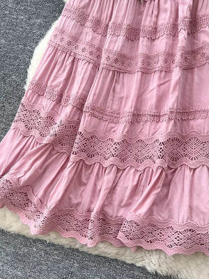 Pink tiered skirt with lace trim and drawstring detail.