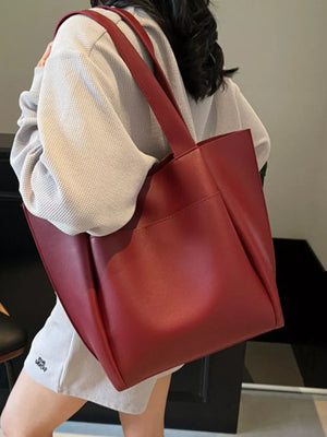 Wine red pu leather tote bag with exterior pocket and shoulder straps.