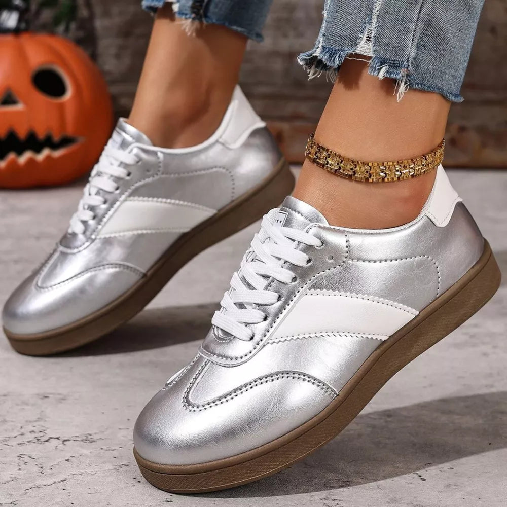Silver patent leather lace-up sneakers with white accents and brown soles