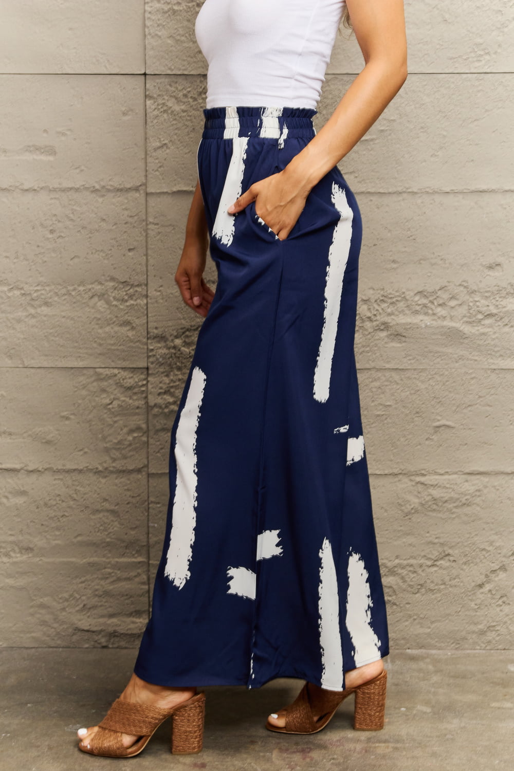 Navy palazzo trousers with white brushstroke pattern and elastic waistband.
