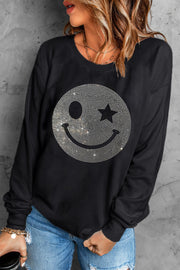 Black crewneck sweatshirt with a rhinestone wink-star smiley face graphic.