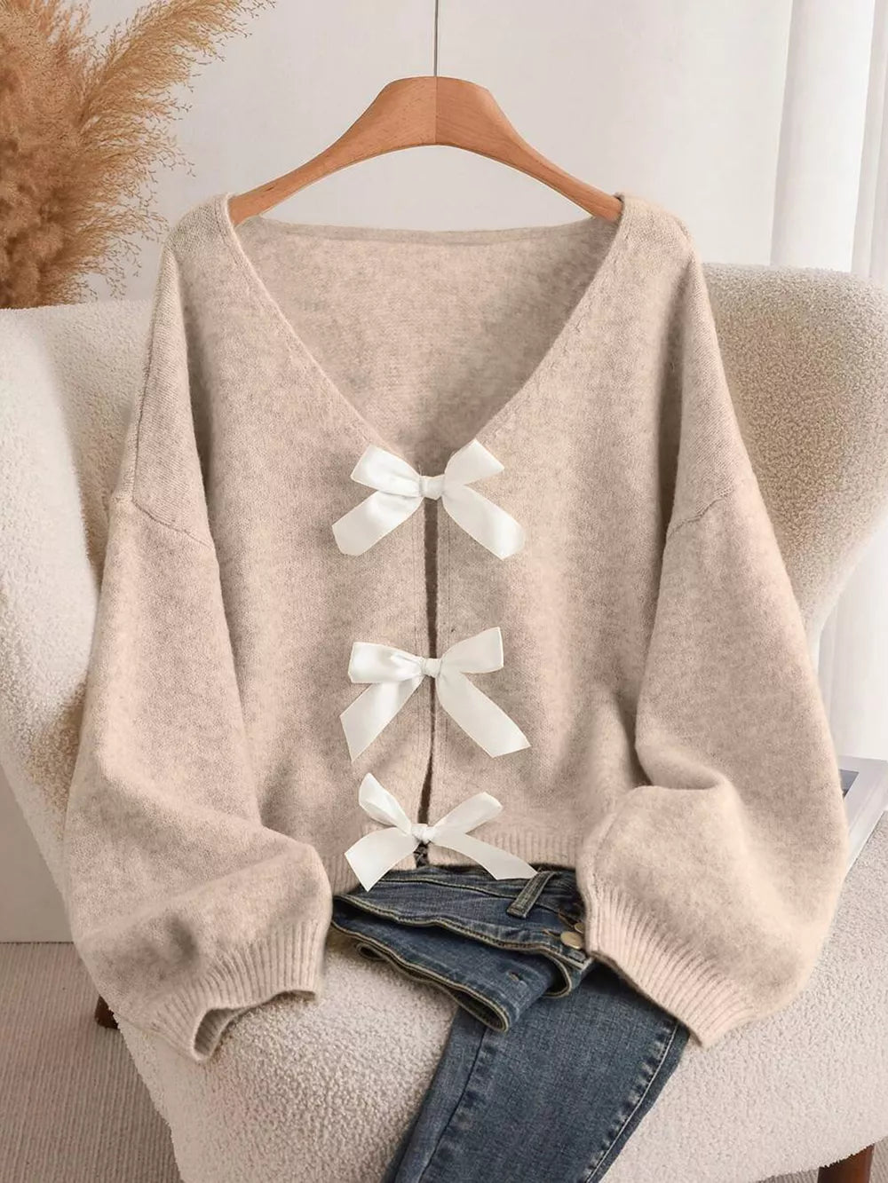 Khaki V-neck cardigan with balloon sleeves and three white bow-knot details.