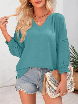 Teal long sleeve polyester blouse with smocked cuffs and V-neck.