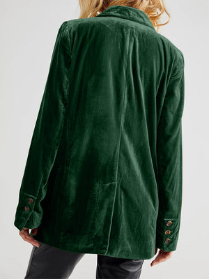 Dark green velvet double-breasted blazer with patch pockets and button detail on sleeve.
