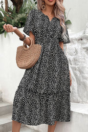 Black smocked waist midi dress with flutter sleeves and a tiered hem.