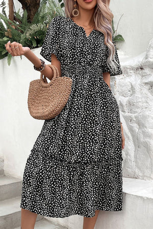 Black smocked waist midi dress with flutter sleeves and a tiered hem.