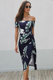 Off-shoulder midi dress in navy with white and green leaf print, featuring a side slit.