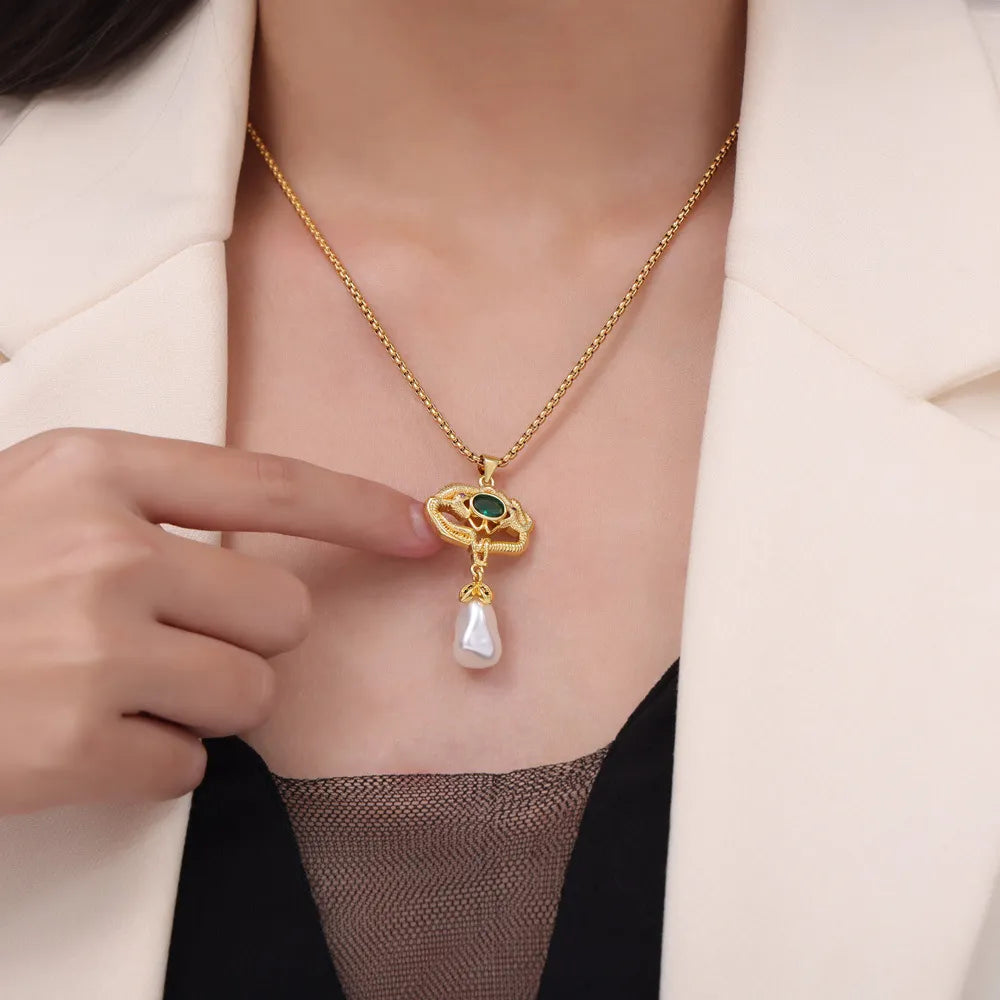 Gold botanical pearl drop pendant necklace with green stone detail.
