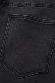 Black wash denim jeans with split hem detail, close-up of back pocket.