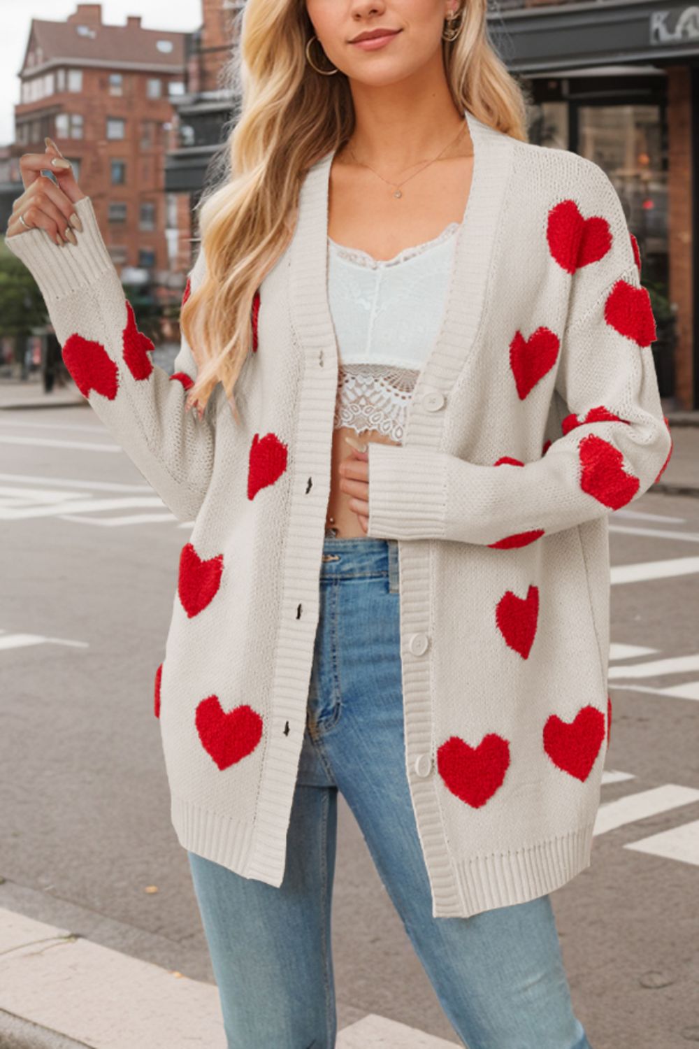 Beige acrylic knit cardigan with red heart appliqués and buttons.