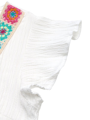 White crinkled maternity blouse with colorful crochet V-neck detail and flutter sleeves.